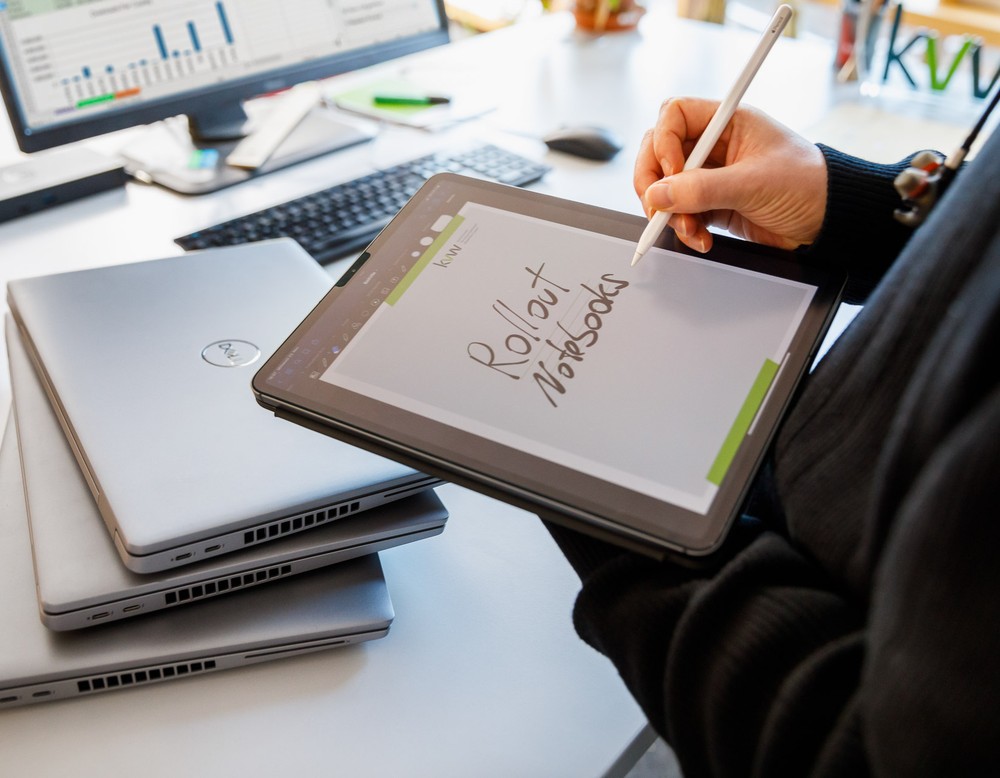 Ein Mitarbeiter der kvw-IT notiert etwas auf einem iPad und organisiert die Ausgabe von Notebooks an die Beschäftigten.